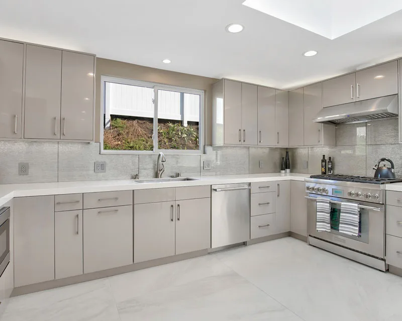 Completed kitchen renovation by Amerbuild featuring glossy custom cabinets, quartz countertops, and stainless steel appliances
