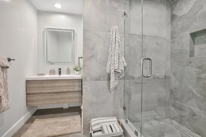 Modern spa-like bathroom remodel by Amerbuild in Los Angeles featuring frameless glass shower and floating vanity
